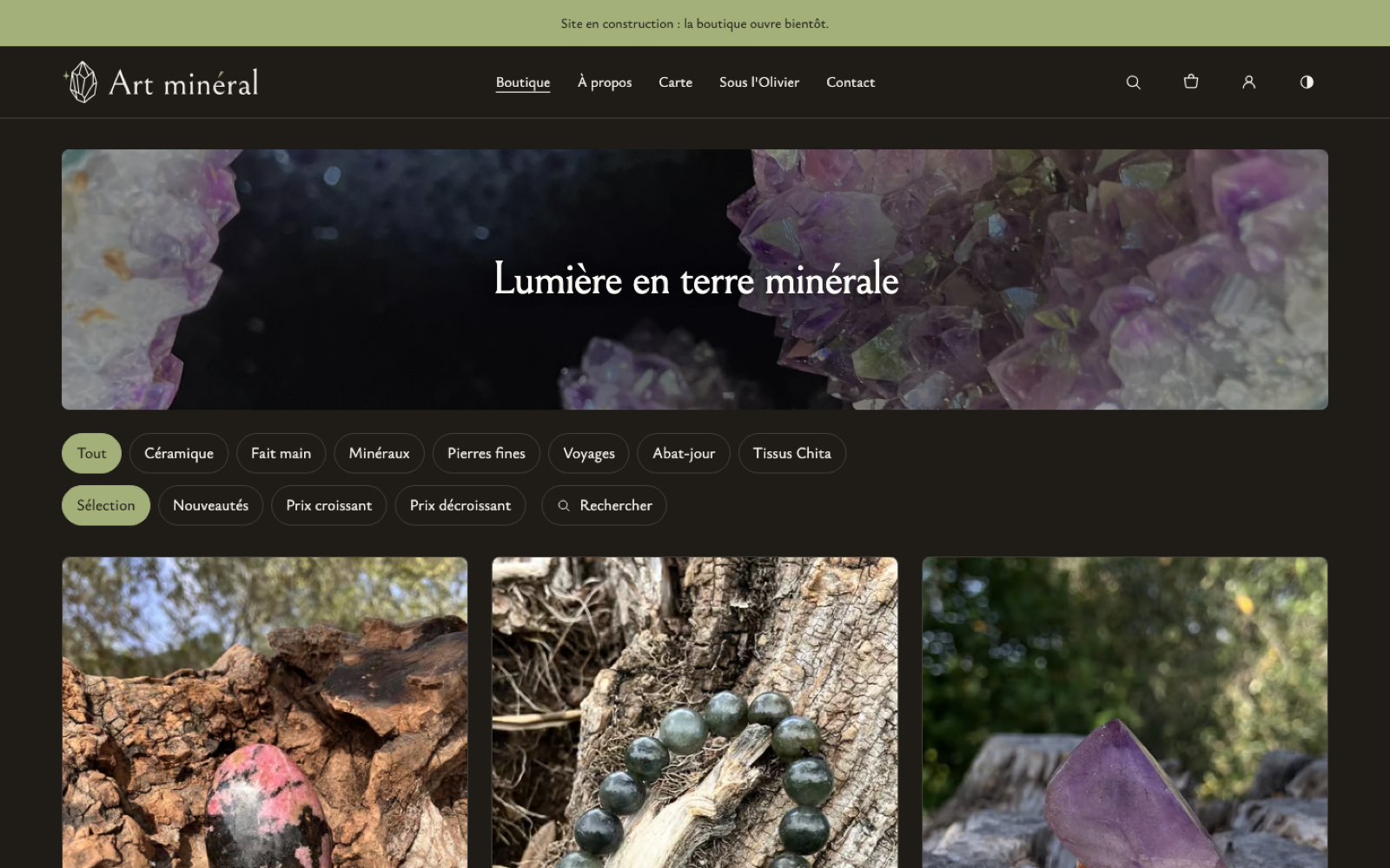 The artmineral.fr shop on desktop: a fine-line crystal logo beside the name, the menu (Boutique, À propos, Carte, Sous l'Olivier, Contact), a wide amethyst geode under “Lumière en terre minérale”, collection and sort filters, and the first stones photographed on bark and wood.